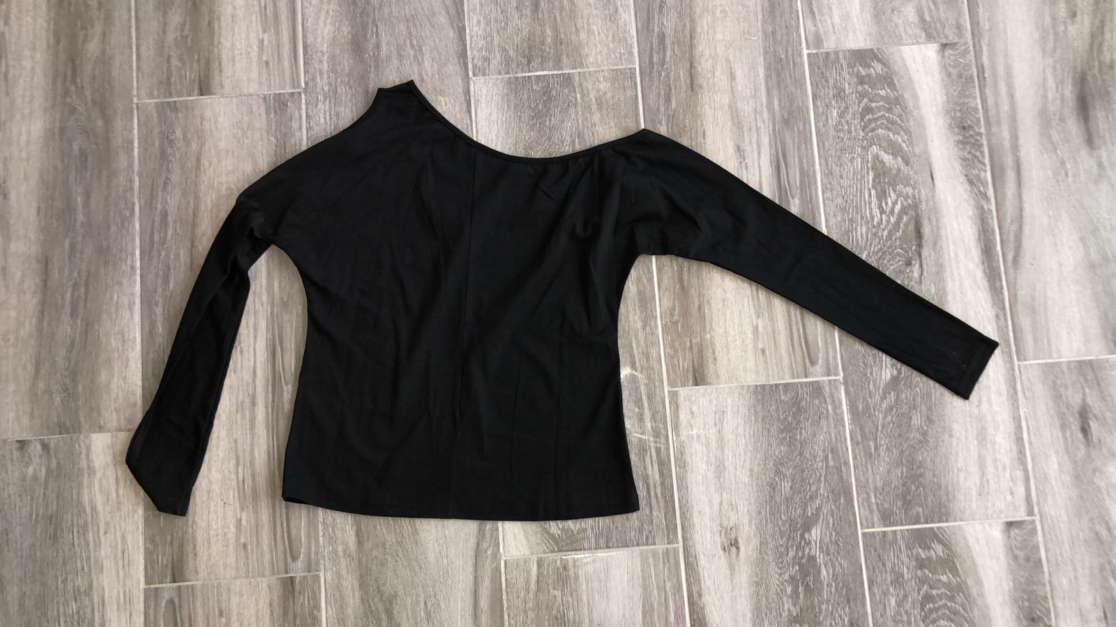 BLUSA CON ABERTURA DE CUELLO ASIMETRICO NEGRA